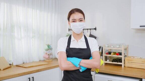 亚洲年轻清洁服务女工在房子工作的肖像漂亮的女管家清洁工戴着口罩拿着拖把清洁工具微笑着做完家务或杂务后看着相机