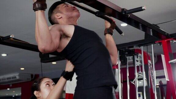 年轻的亚洲肌肉男子锻炼做引体向上在健身房的酒吧生活方式运动和健身概念