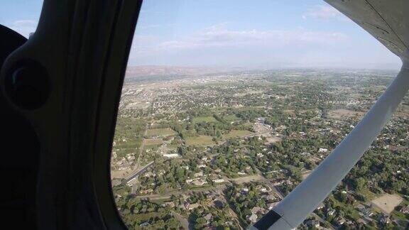 一架小型单引擎飞机飞过科罗拉多州的一个乡村小镇