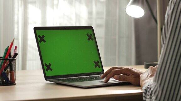 用绿色屏幕的笔记本电脑的人