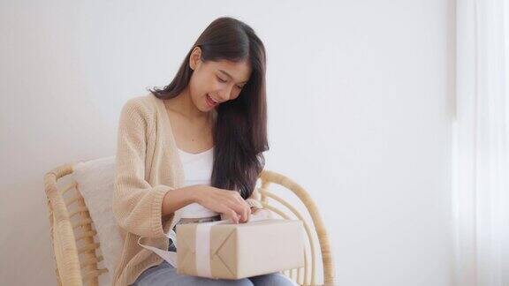 亚洲年轻女子打开礼品盒新年快乐感恩节快乐