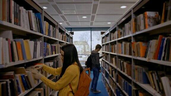 两个学生在图书馆的书架上找书