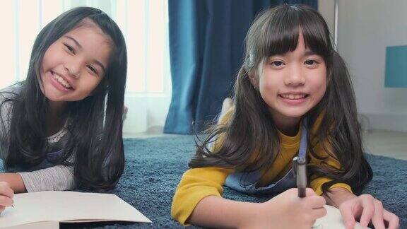 年轻的亚洲女儿兄弟姐妹孩子幸福躺在地板客厅网上学习的家庭背景