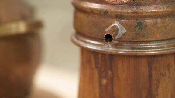水滴从木支架上的金属罐子里流出的特写镜头