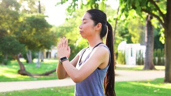亚洲健身女性在公园户外练习瑜伽