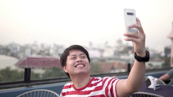 亚洲男人用智能手机拍照或视频