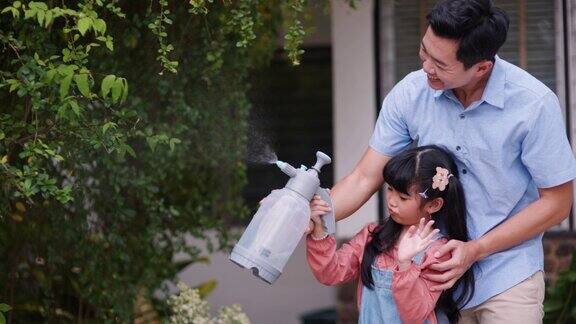 亚洲父亲教他的女儿照顾花园同时浇树