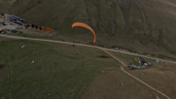 鸟瞰图橙色滑翔伞飞行极限运动活动山区岩石地形