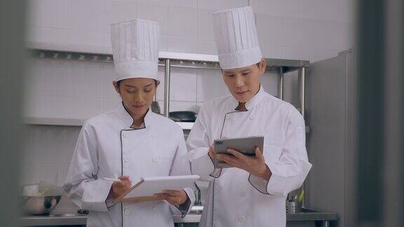 两位厨师使用平板电脑进行检查和讨论在厨房做饭