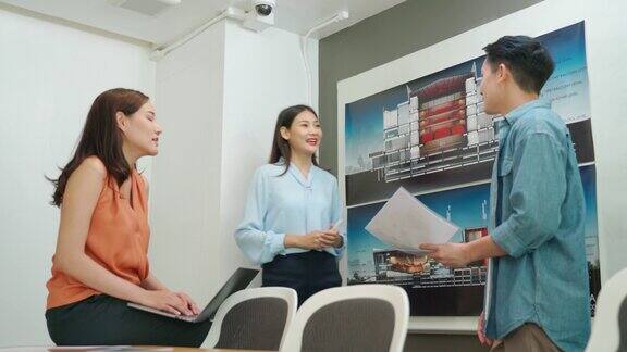 业务展示东南亚建筑师在会议室向同事展示房地产项目施工方案