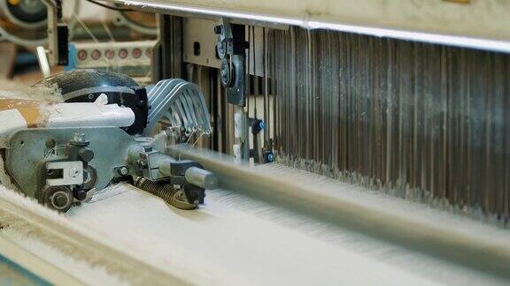 编织织机纺织工厂纺织工业特写镜头自动织布机正在织造线布纺织厂设备面料生产