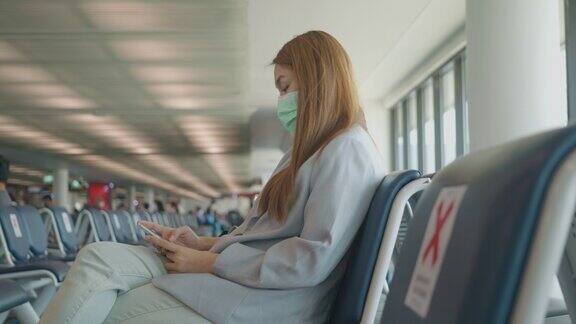 东南亚商务女性在机场用智能手机办理登机手续