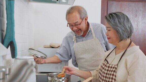 夫妇老亚洲长者幸福生活在家庭厨房爷爷和奶奶一起煮沙拉菜快乐地微笑着一起享受退休生活老年人的关系和活动