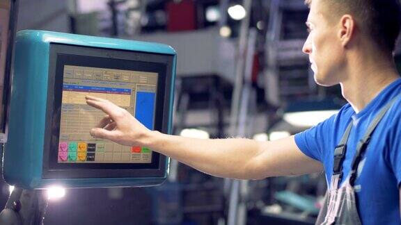 工程师使用工业机器的触摸屏选择工厂设备