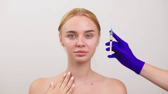 一个没有化妆的年轻女子她旁边是一个装有液体的注射器