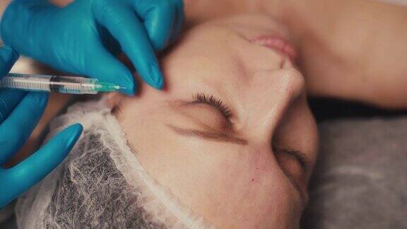 美容和注射有经验的美容师用所需的活性成分进行皮下穿刺以收紧和提升女性面部