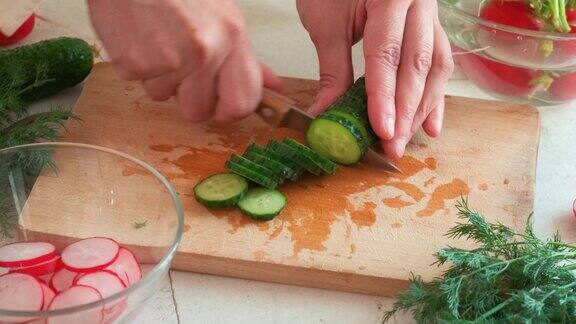 用萝卜黄瓜洋葱莳萝做新鲜的夏季沙拉男人用刀割黄瓜健康的减肥食品