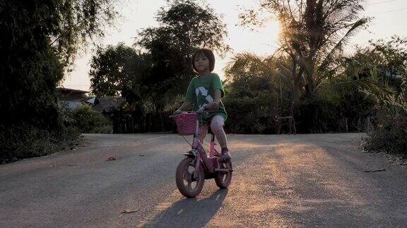 小女孩在乡村的路上骑自行车
