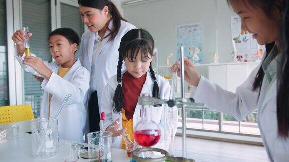 教师授课并向小学生讲解化学他们在学校实验室的烧杯中学习科学和化学混合
