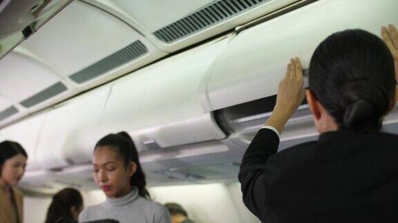 乘客在飞机上将行李放入头顶行李箱
