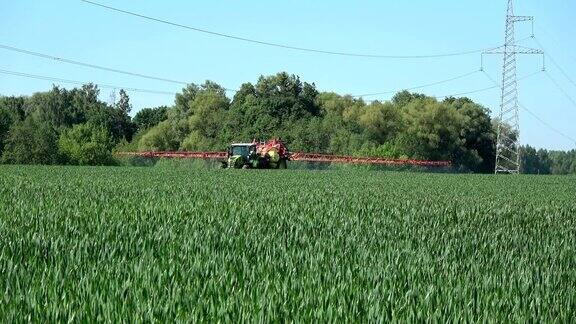 拖拉机在春季向麦田喷洒化学药剂