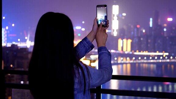 年轻女子正在拍摄城市夜景