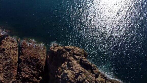 景观无人机视图立交桥闪闪发光的海水溅在高岩石悬崖在日落