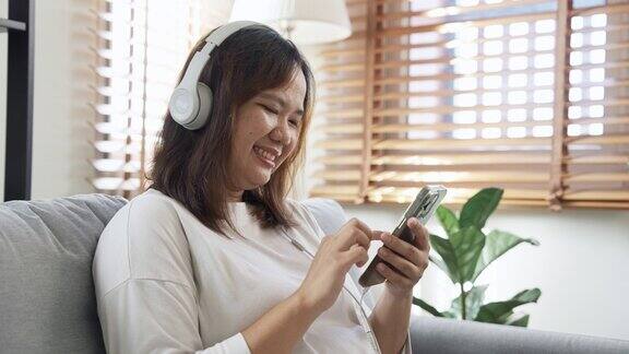年轻女子喜欢用智能手机听音乐或看视频媒体