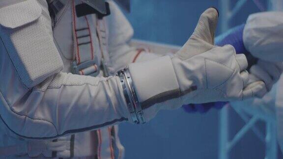 科学家帮助宇航员戴上手套