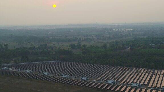 日落时太阳能发电厂的鸟瞰图阳光反射在太阳能电池板上