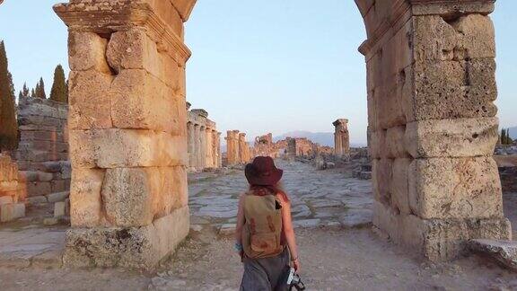 一名摄影师游客正走向位于帕穆克卡莱希拉波利斯古遗址中的Frontinus门