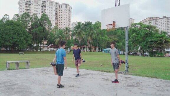 3个亚洲中国少年在周末早上一起做篮球赛前的热身运动