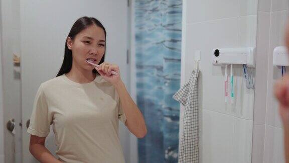 4K年轻的亚洲妇女在浴室刷牙
