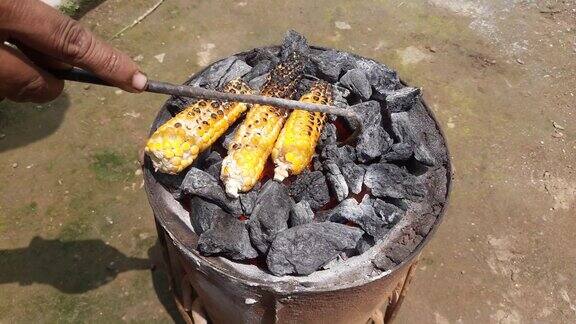 在煤炉上烤玉米棒