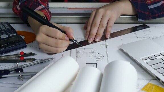 特写有吸引力的年轻女建筑师在书桌上与蓝图计划