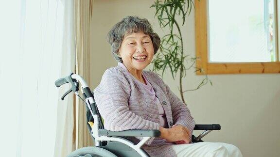 坐在轮椅上的老妇人在窗边笑