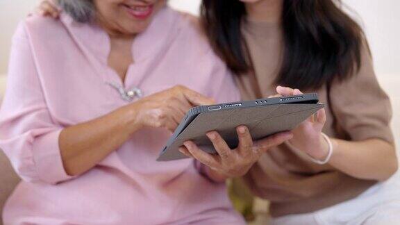 孙女在家里和祖母一起使用数码平板电脑