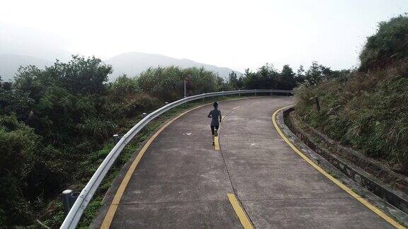 空中拍摄的健身女跑步者在山顶的小道上跑步