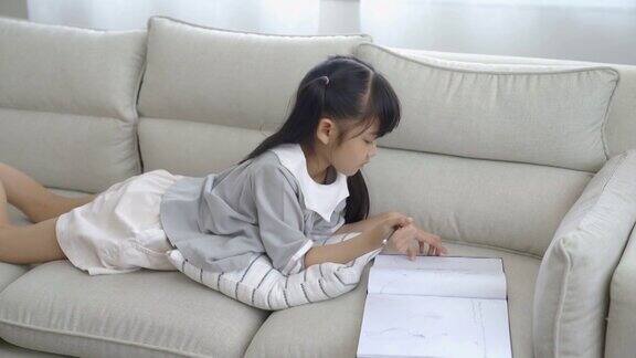 可爱的女孩在沙发上画画画画