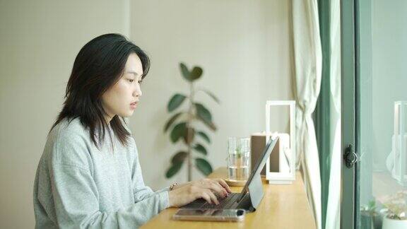 亚洲女性在家使用数码平板电脑