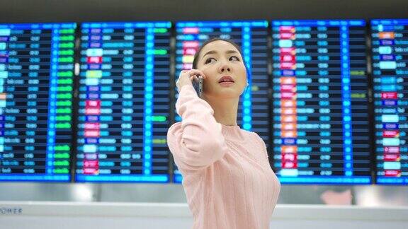 4K亚洲女子在机场候机楼查看时刻表
