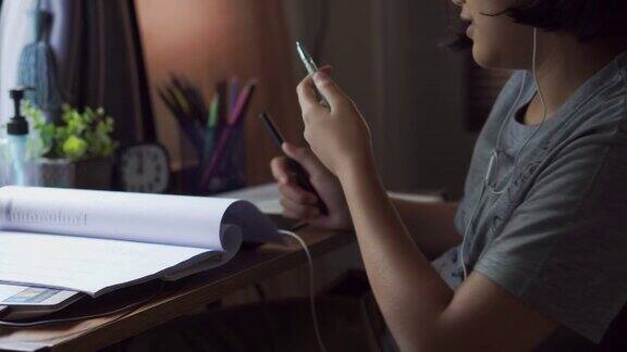 亚洲孩子在家写作和做作业亚洲儿童使用笔记本电脑学习快乐泰国学生在线学习为考试学习在线教育