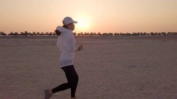 日落时分在沙滩上慢跑的女人