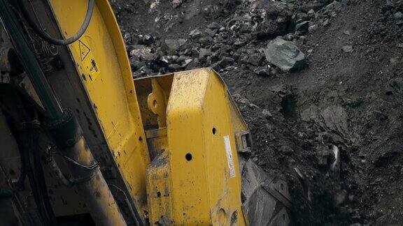一台大型挖掘机将铲斗插入地下将矿石耙入矿石开采一个采石场一个水桶的特写4k