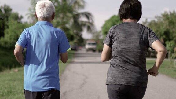2对亚洲华人老年夫妇早上在公园慢跑