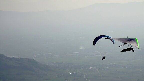 滑翔伞和滑翔伞飞越迷雾山谷