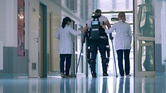医生们正在帮助一名戴着外骨骼的男子走路