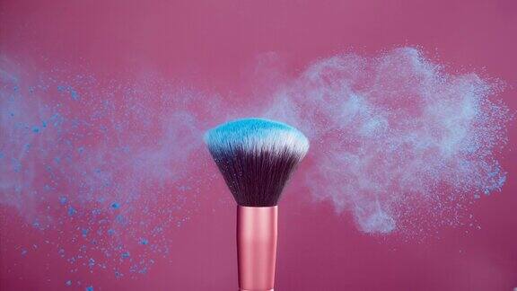化妆刷与粉红色背景上的蓝色粉末爆炸超级慢动作