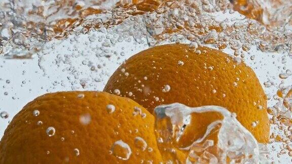 新鲜的橘子落下的水使气泡近距离有机热带果汁