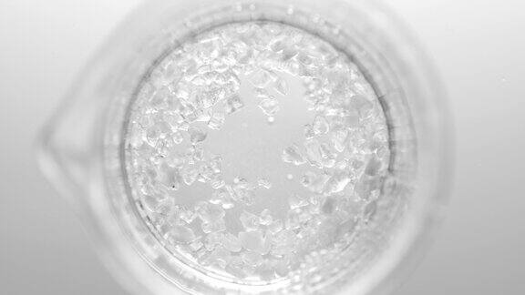 水晶落在烧瓶中形成透明液体产生气泡
